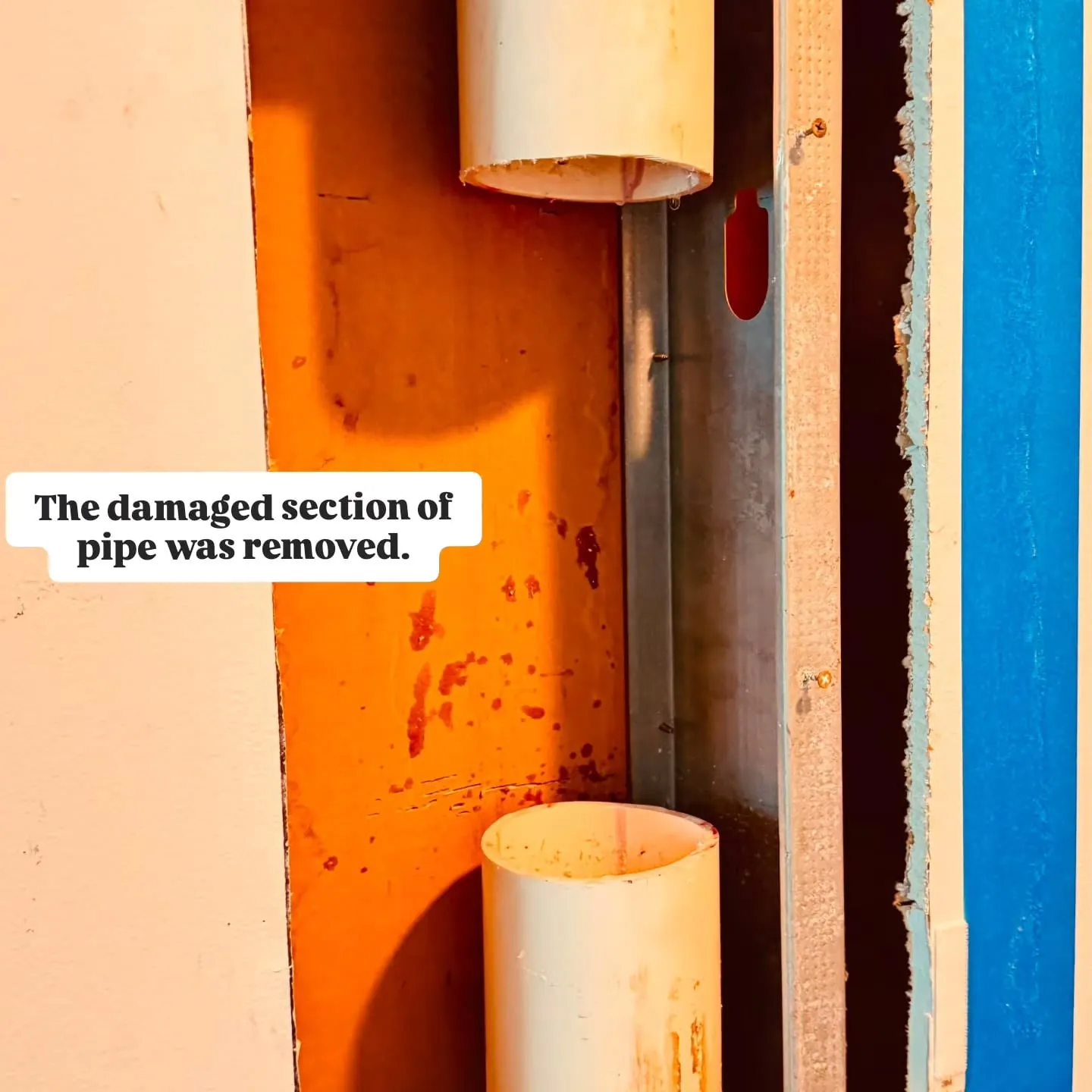 Gap in a PVC drain stack where the damaged section was cut out
