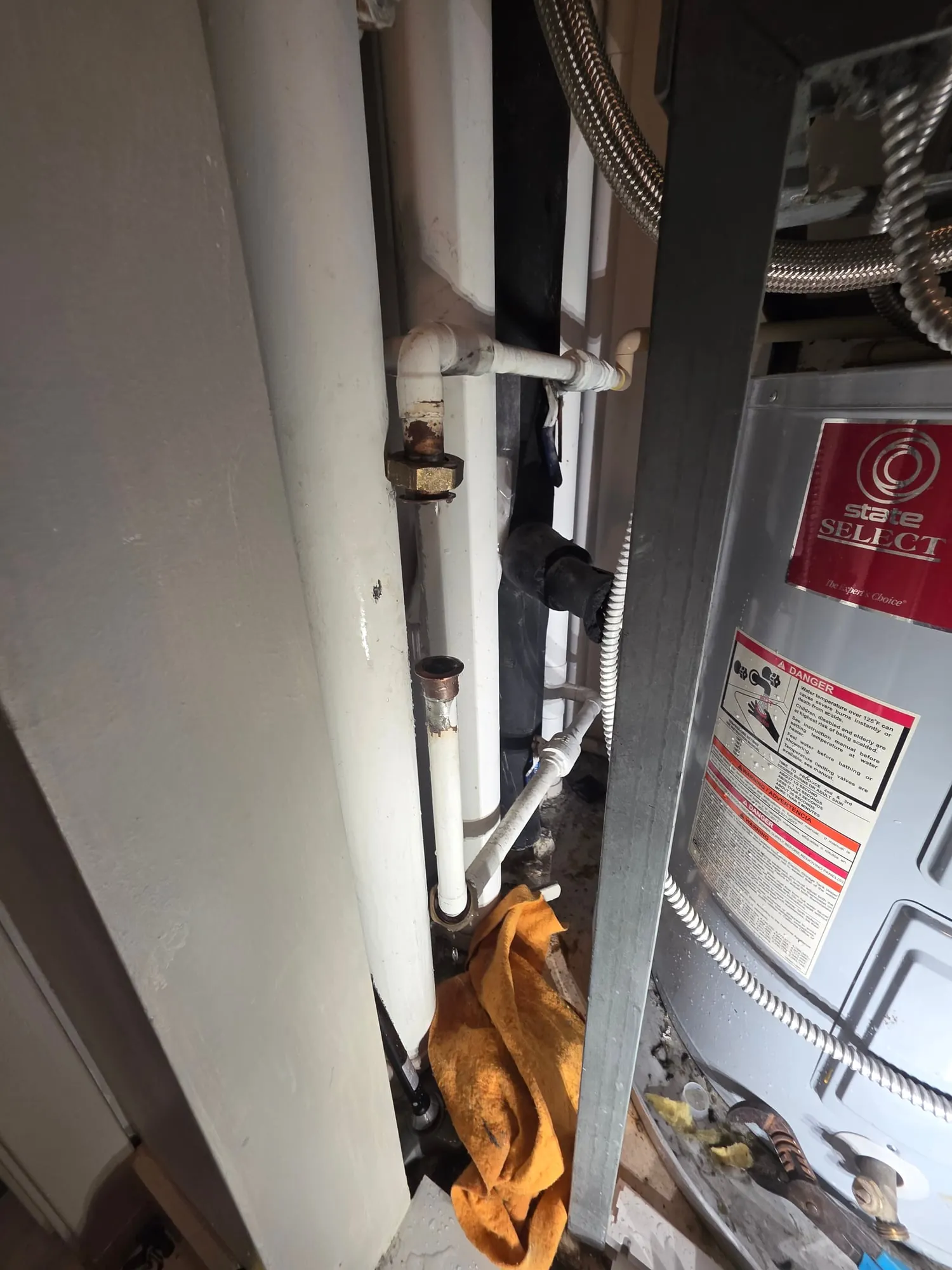 Electric water heater in a tight closet next to a vertical riser