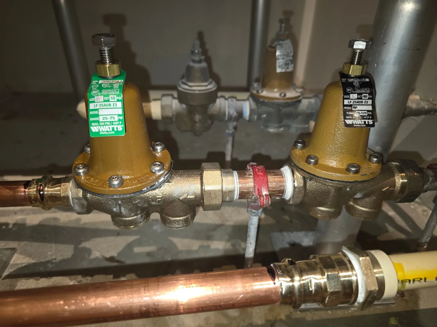 Close-up of two new brass pressure reducing valves with their tags