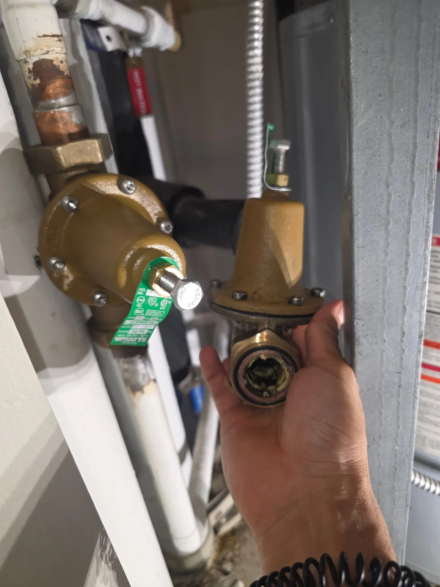 A pressure reducing valve on a vertical line with a second valve held up beside it