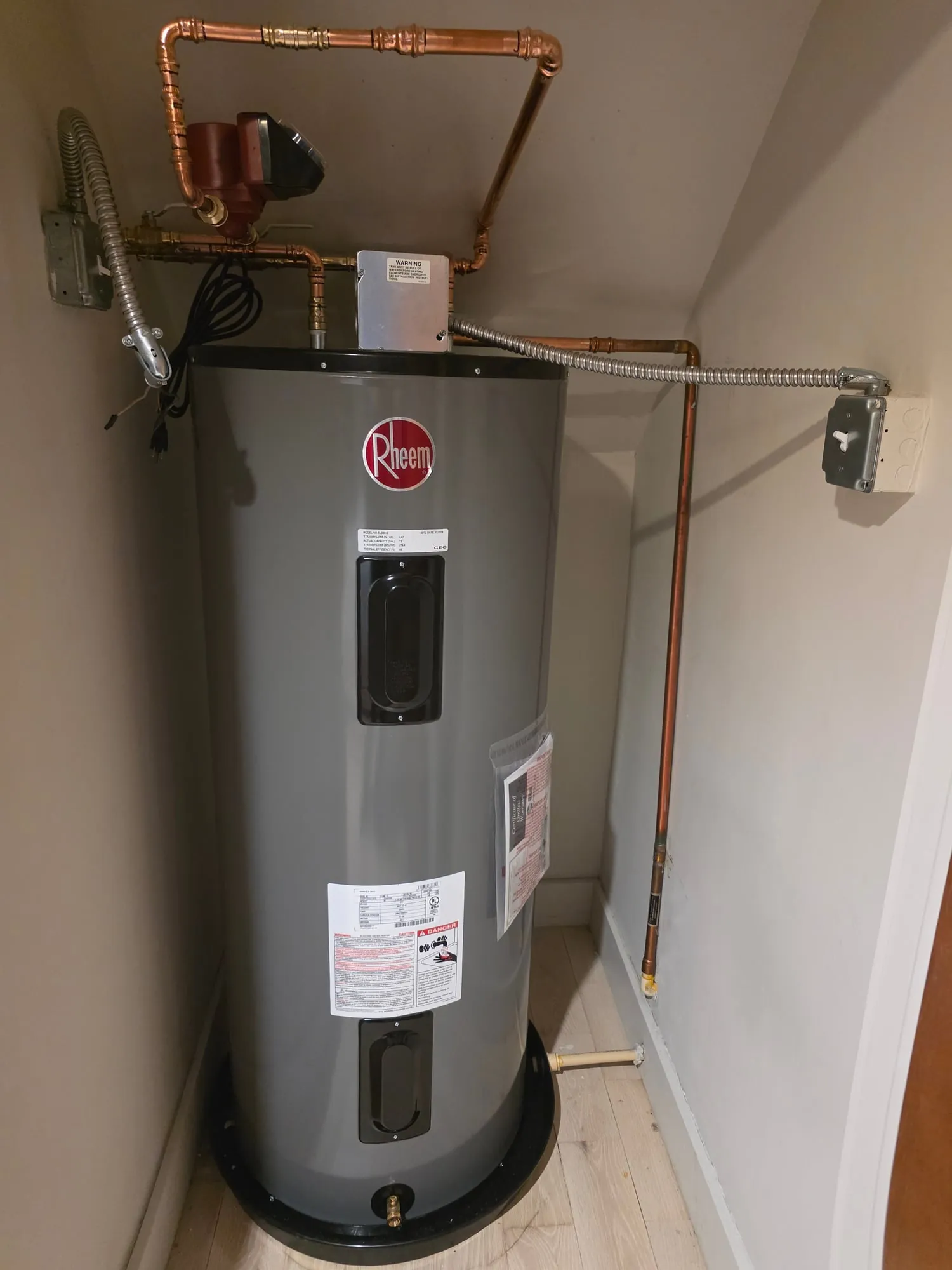 Rheem electric water heater in a closet with a sloped ceiling