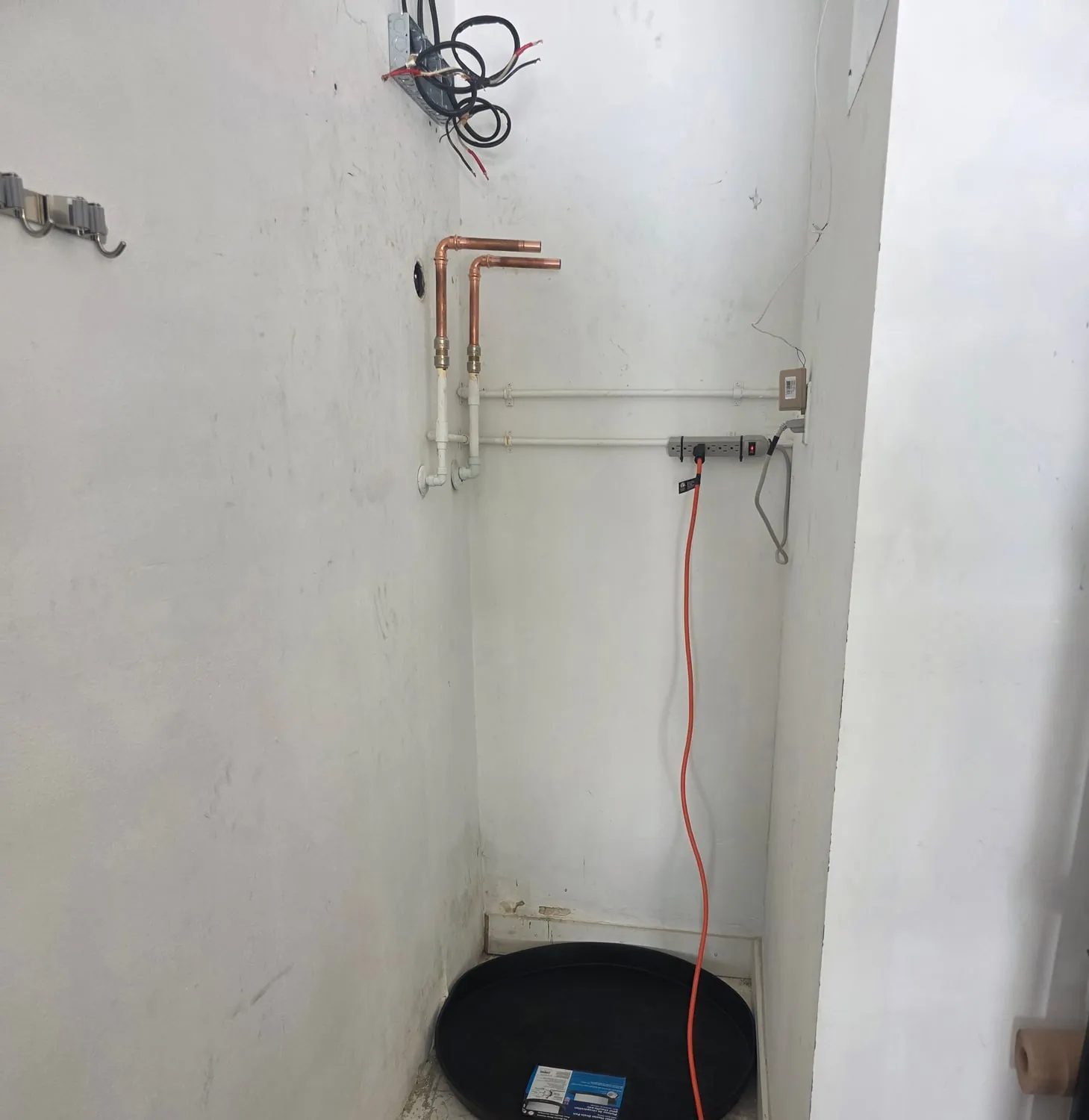 Corner closet with copper stub-outs, a drain pan and an orange cord